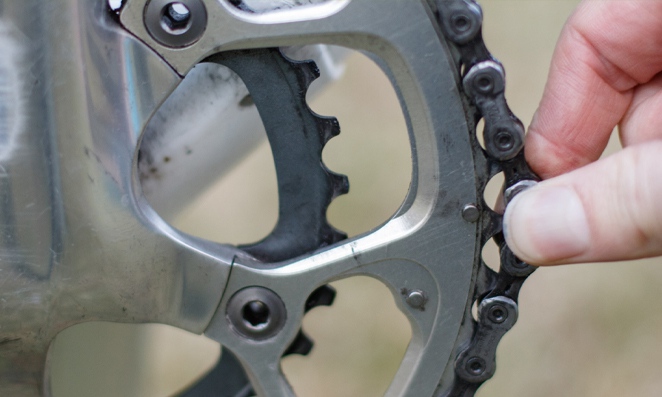 Pessoa mexendo em corrente de bicicleta