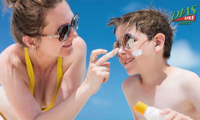 Mãe passando protetor solar no filho