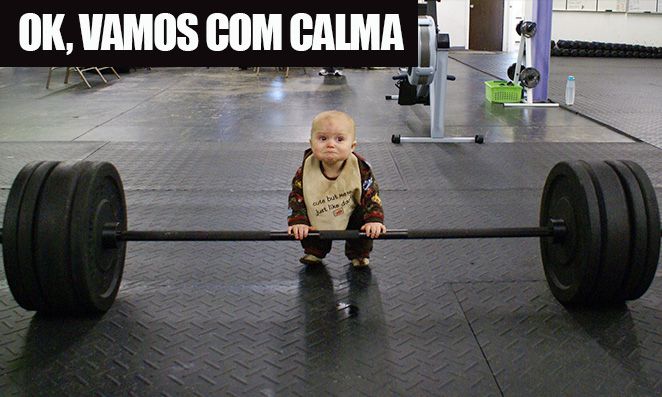 Criança pequena segurando barra com pesos