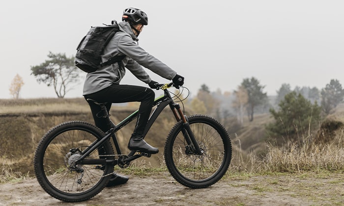 Homem parado em cima de uma bike na trilha