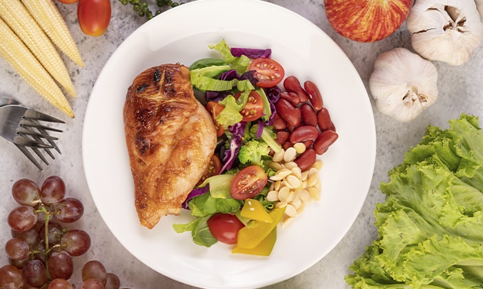 Prato de alimento com frango, salada e grãos