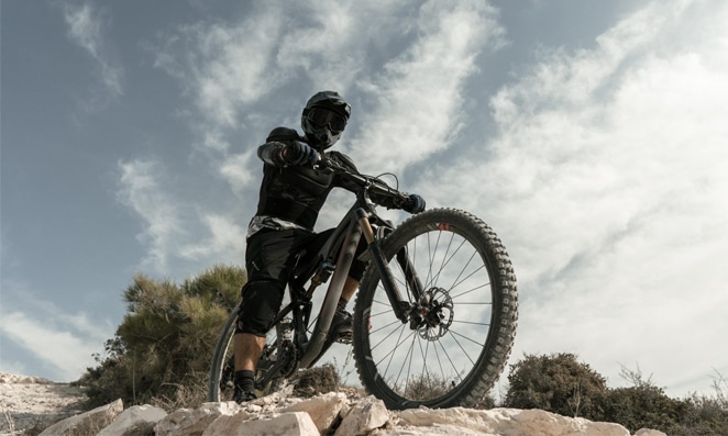 Ciclista com uma bicicleta e vestindo vários equipamentos de segurança
