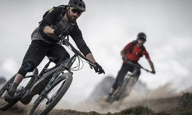 Homens fazendo trilha com bike