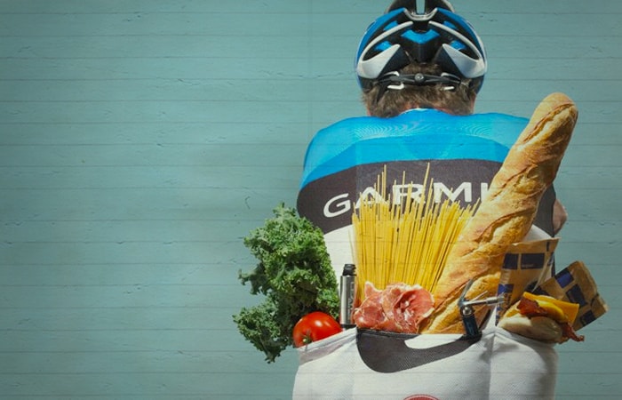 Imagem de um ciclista com alimentos necessários para um percursos longo