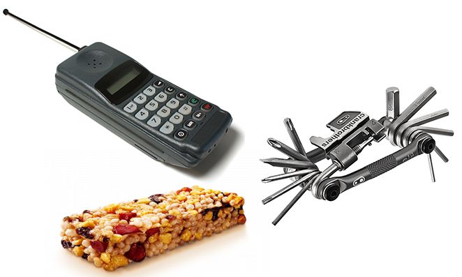 Barra de cereal, celular antigo e kit de ferramentas para bicicleta