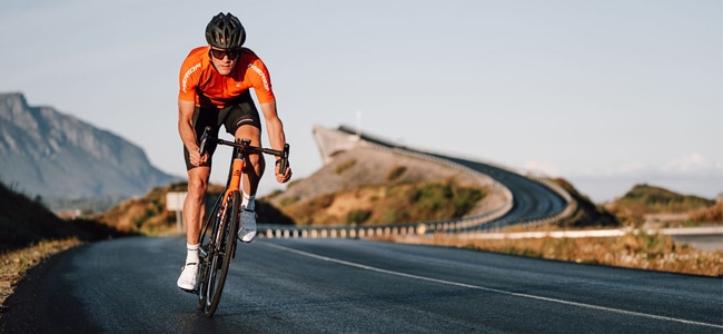 Ciclista pedalando na estrada com uma bike road