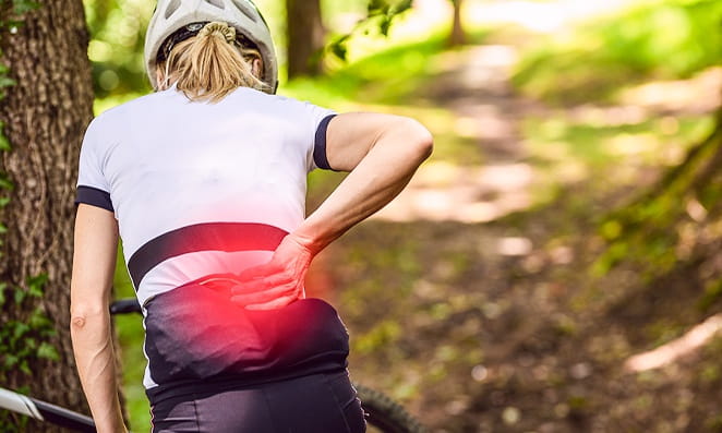 03 Overtraining Mulher ciclista com dor nas costas