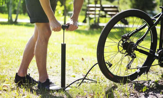 Homem calibrando o pneu de bicicleta