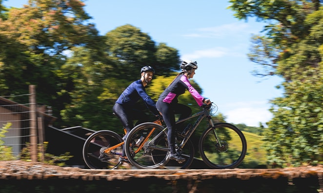 Casal andando de bicicleta em uma estrada de chão