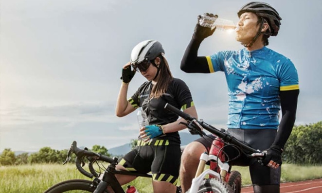 Casal se hidratando durante o percurso de bicicleta