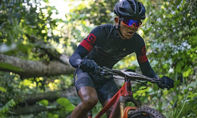 Homem andando de bicicleta usando vários acessórios de proteção