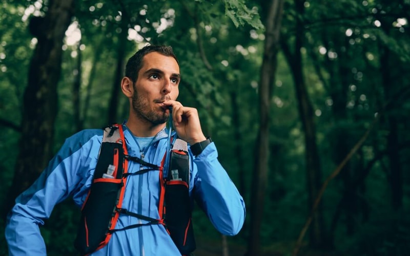 Homem bebendo água durante o ciclismo utilizando uma mochila de hidratação