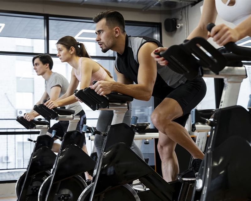 pessoas praticando ciclismo indoor na academia
